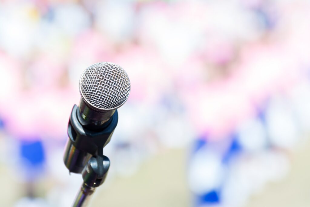 Image of a microphone at a blurred press conference